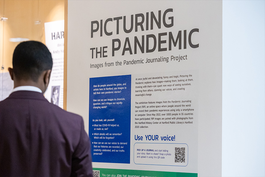 A visitor browses the Picturing the Pandemic art exhibit.