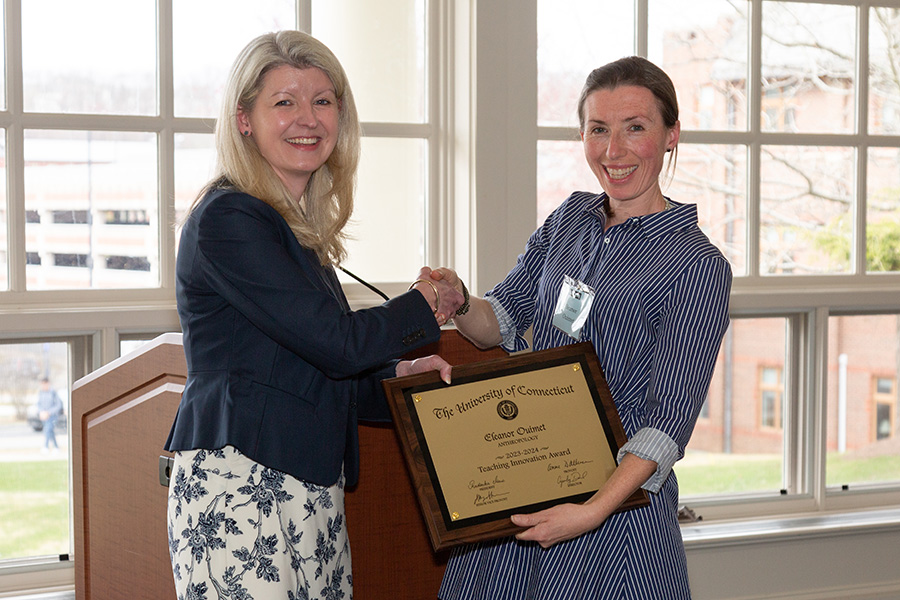Eleanor Ouimet shakes hands with a CETL representative while receiving her award.